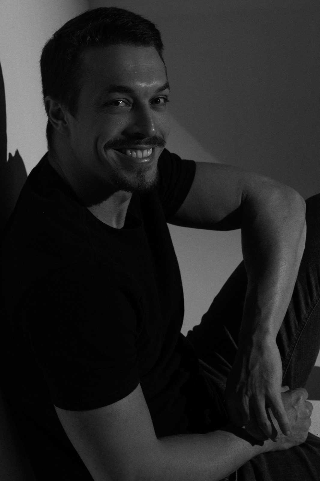 Felipe Fávaro sorrindo sob luz de estúdio